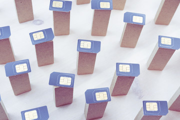 Fototapeta premium SIM cards are on top of the bars standing vertically on a light wooden surface, top view of the SIM card