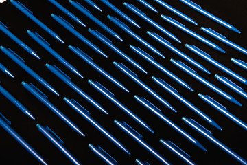 Blue pens on black background 