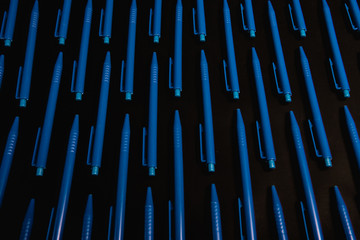 Blue pens on black background 