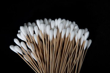 Fototapeta na wymiar Wood, cotton buds isolated on a black background