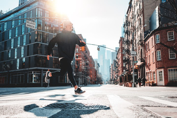 Obraz na płótnie Canvas Urban male athlete running on asphalt through the New-York streets. Fast man runner wearing sportswear preparing for marathon