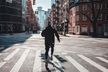 Strong man runner training and running through urban streets. Athlete prepearing for marathone on...