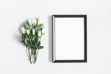 Flowers composition. White rose flowers, photo frame on pastel gray background. Valentines day, mothers day, womens day, spring concept. Flat lay, top view, copy space