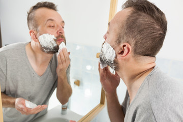 Man applying shaving cream on beard