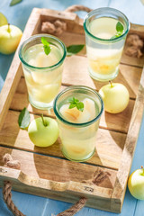 Delicious apple juice on blue wooden table