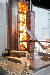 Turkish Doner Kebab, Shawarma or Gyros. Chef cutting with doner knife Traditional Turkish Doner...