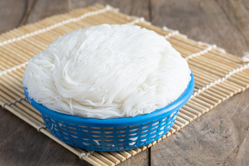 Rice vermicelli white In a blue basket on wood table Is a savory food that Thai people prefer popular to eat.