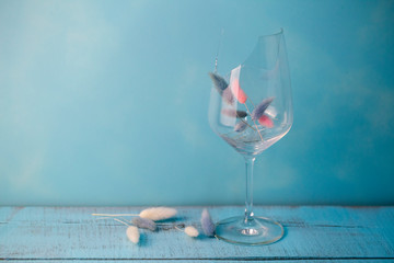 broken glass of wine on blue wooden background