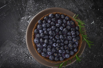 Blueberry vegan cheesecake. Dark photo on black background