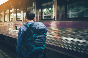 Hipster man standing at platform train station waiting and looking future concept.