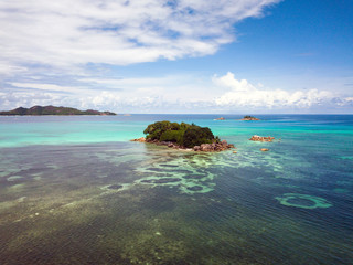 Fototapeta na wymiar A small island with a blue lagoon somewhere in the Seychelles