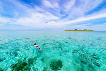 Fototapeta na wymiar Woman snorkeling on coral reef tropical caribbean sea, turquoise blue water. Indonesia Wakatobi archipelago, marine national park, tourist diving travel destination