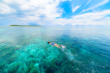 Woman snorkeling on coral reef tropical caribbean sea, turquoise blue water. Indonesia Wakatobi archipelago, marine national park, tourist diving travel destination - obrazy, fototapety, plakaty