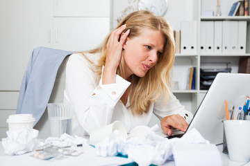 Frustrated business woman among papers