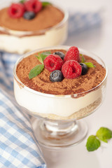 The popular Italian dessert tiramisu in a glass with fresh berries