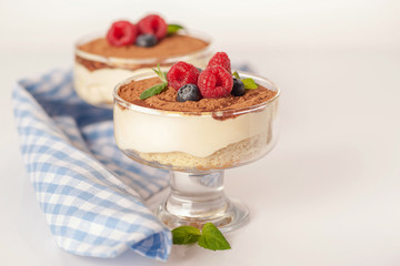 The popular Italian dessert tiramisu in a glass with fresh berries
