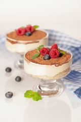 The popular Italian dessert tiramisu in a glass with fresh berries