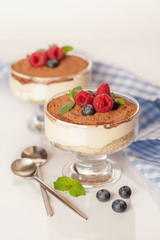 The popular Italian dessert tiramisu in a glass with fresh berries