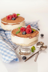 The popular Italian dessert tiramisu in a glass with fresh berries