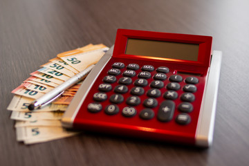 Taschenrechner und Geld in Büro auf einem Schreibtisch