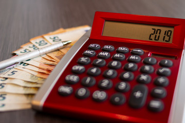 Finanzkonzept mit Taschenrechner, Kugelschreiber und 50 Euro Scheinen auf einem Büro Schreibtisch
