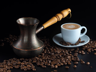 Old Cezve, white coffee cup with coffee and coffee beans on a dark background.