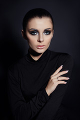 Fototapeta na wymiar Classic Smokey makeup on woman face, beautiful big eyes. Fashion Perfect makeup, expressive eyes on girl face, smooth black eyebrows, licked brunette hair. Portrait of a woman on a dark background