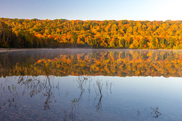 Autumn Lake Reflections. Vibrant fall foliage reflected in the clear water of Monocle Lake in the Hiawatha National Forest in the Upper Peninsula of Michigan.