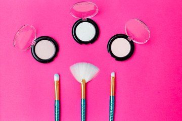 Makeup brushes mermaid tail  and eye shadow on a bright pink background. Flat lay