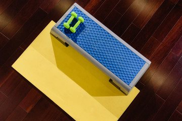 Set of fitness accessories: step platform, yoga mat and dumbbells