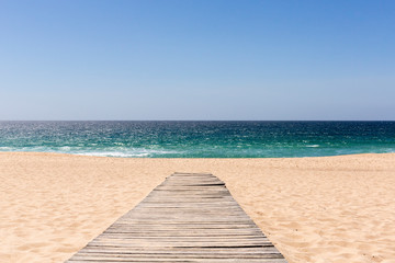 Wooden board walk leading to a sandy beach and the sea - Powered by Adobe