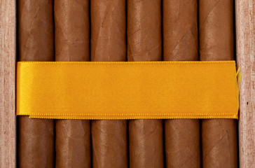 packing of Cuban cigars in a box with a yellow ribbon. mockup on yellow tape