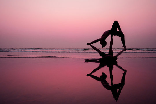 muladhara swadhisthana manipula tantra yoga on the beach man and woman meditates sitting on the sand by the sea at sunset romantic Valentine's Day.couple practicing yoga steam