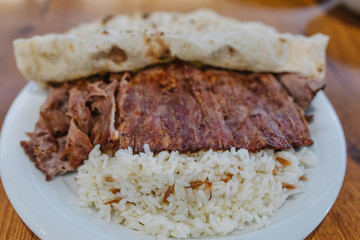 Turkish Doner Kebab, Shawarma or Gyros with rice. Traditional Turkish Doner Kebab meat, iskender, shawarma or gyros in restaurant