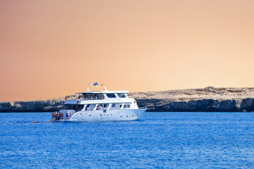 Yacht in blue lagoon on sunset. Tourist boat in Cyprus. Vacation, holiday background or concept.