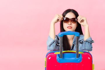 Traveler tourist woman in summer casual clothes.Asian Smiling woman wearing sun glasses.Passenger traveling abroad to travel on pink background.