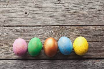 Line of easter eggs on wooden background.