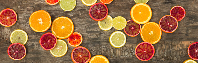 Fototapeta na wymiar many different juicy and healthy citrus fruits lie together on an old, vintage wood background