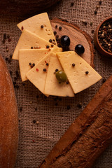 Slices of cheese on wooden desk between different breads. place for text