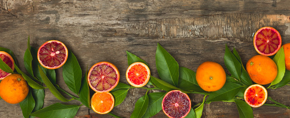 fresh, juicy oranges and blood oranges lie on an old wooden background