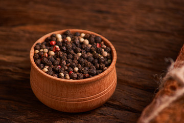 Peppercorns in a wooden bowl on table with food rustic style. Homemade food
