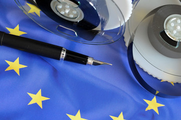 Taśmy i pióro na tle flagi UE - obrazy, fototapety, plakaty