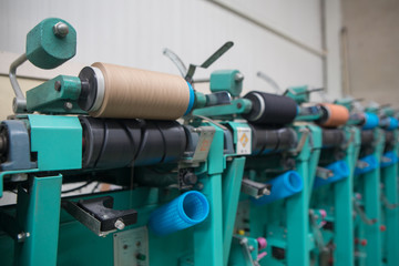Group of bobbin thread cones on a warping machine in a textile mill. Yarn ball making in a textile factory. Textile industry - yarn spools on spinning machine in a textile factory