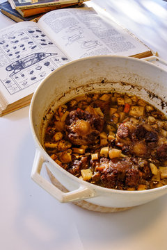 Oxtail Stew In White Cast Iron Dutch Over With Old Cookbooks And Recipes