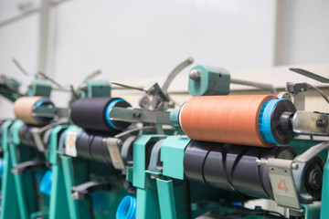 Group of bobbin thread cones on a warping machine in a textile mill. Yarn ball making in a textile factory. Textile industry - yarn spools on spinning machine in a textile factory