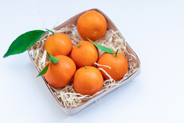Tangerines with green leaves in a basket 