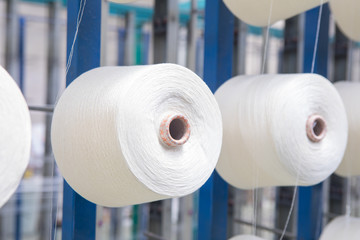 Group of bobbin thread cones on a warping machine in a textile mill. Yarn ball making in a textile factory. Textile industry - yarn spools on spinning machine in a textile factory - Powered by Adobe