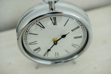 a silver vintage clock on the nighstand