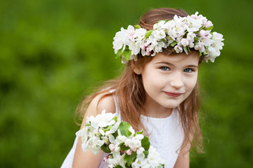Beautiful young girl in white dress in the garden with blosoming  apple trees. Smiling girl  having fun and enjoying