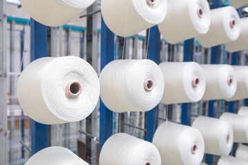 Group of bobbin thread cones on a warping machine in a textile mill. Yarn ball making in a textile...